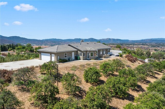 exterior space featuring a mountain view, central AC, and a garage