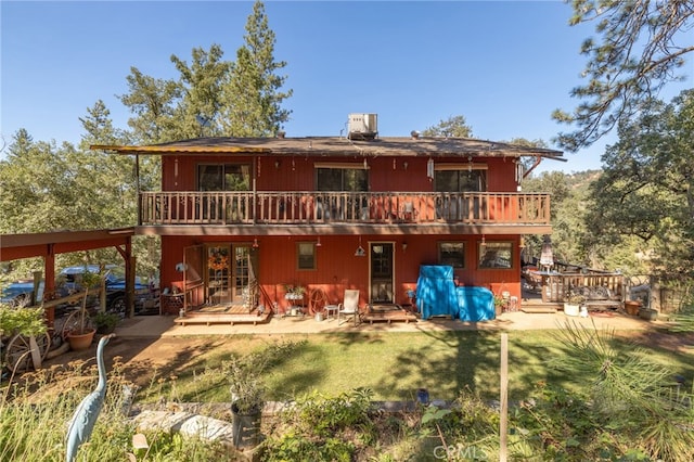 back of property with a lawn, a patio area, a balcony, and central air condition unit