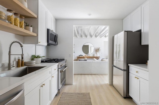 kitchen featuring white cabinets, light hardwood / wood-style floors, stainless steel appliances, and sink