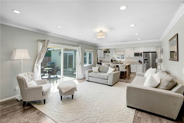 living room with crown molding and light hardwood / wood-style floors