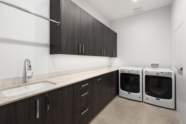 washroom with sink, washing machine and dryer, and cabinets