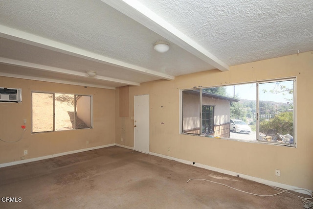 spare room featuring beam ceiling, a textured ceiling, carpet floors, and a wall mounted air conditioner