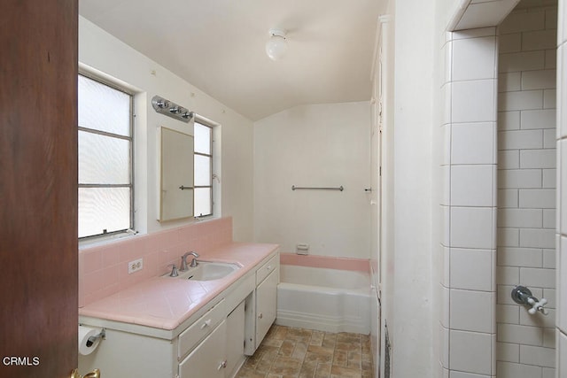 bathroom featuring shower with separate bathtub, vanity, backsplash, and a healthy amount of sunlight