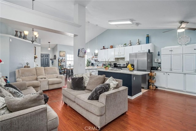 living room featuring high vaulted ceiling, dark wood-type flooring, and ceiling fan with notable chandelier