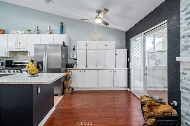 kitchen with ceiling fan, dark hardwood / wood-style floors, vaulted ceiling, white cabinets, and appliances with stainless steel finishes