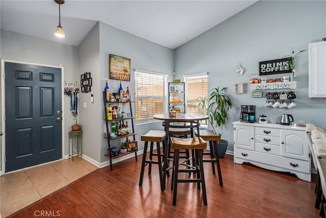 dining room with dark hardwood / wood-style flooring and lofted ceiling