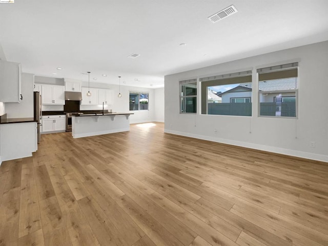 unfurnished living room with plenty of natural light and light wood-type flooring