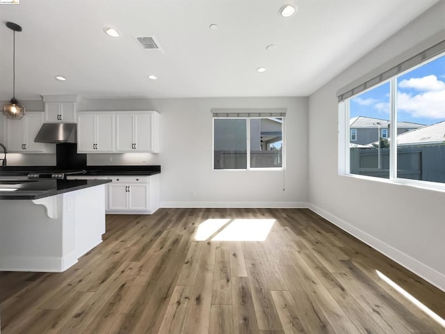 kitchen featuring white cabinets, hanging light fixtures, and dark hardwood / wood-style floors