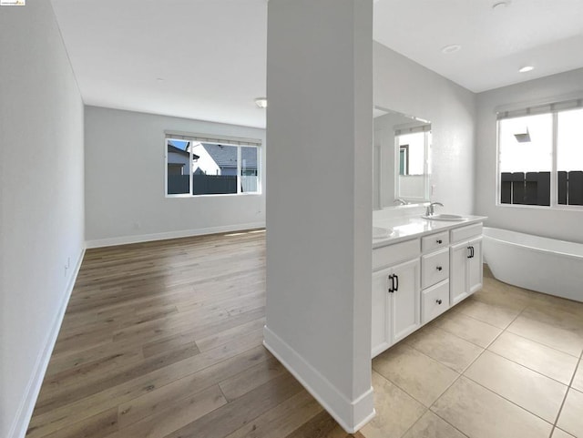 bathroom with a tub to relax in, hardwood / wood-style floors, and vanity