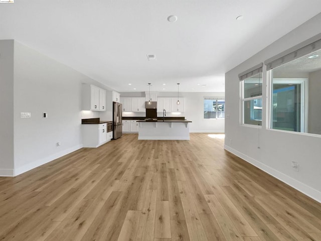 unfurnished living room featuring light hardwood / wood-style floors and sink