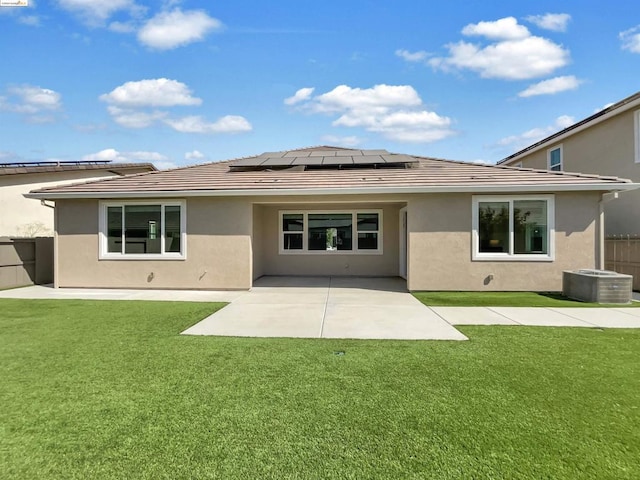 back of house featuring solar panels, a yard, central AC, and a patio area