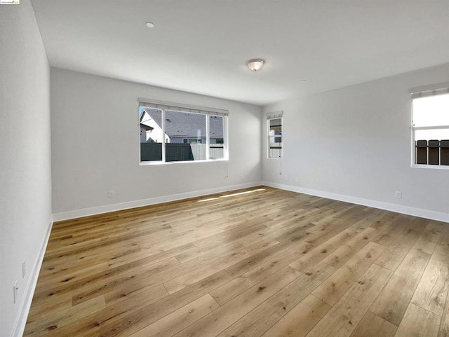 unfurnished room with light hardwood / wood-style floors and a wealth of natural light