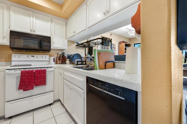 kitchen featuring ceiling fan, white cabinetry, black appliances, tile counters, and sink