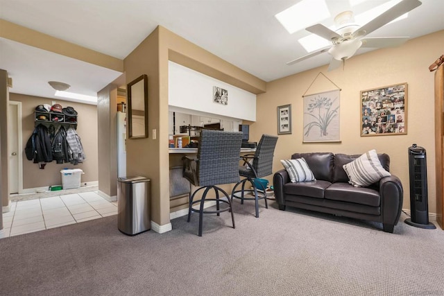 interior space featuring light carpet, indoor bar, a skylight, and ceiling fan