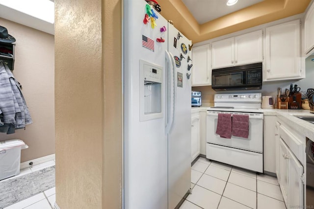 kitchen featuring white cabinets, light tile patterned floors, and white appliances