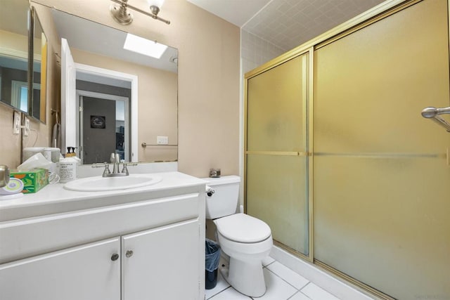 bathroom featuring toilet, a skylight, vanity, an enclosed shower, and tile patterned flooring