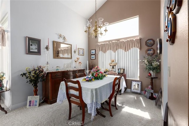 carpeted dining space with high vaulted ceiling and an inviting chandelier