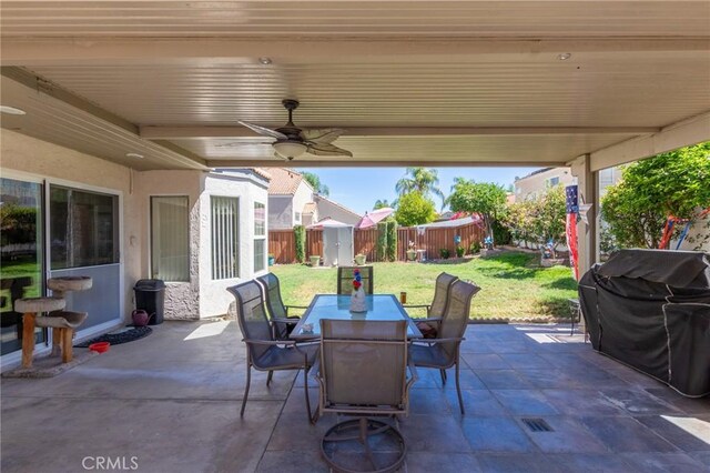 view of patio with grilling area, a storage unit, and ceiling fan