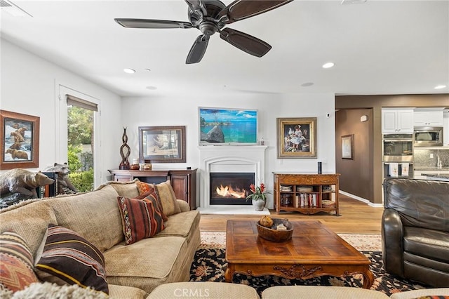 living room featuring light hardwood / wood-style floors and ceiling fan