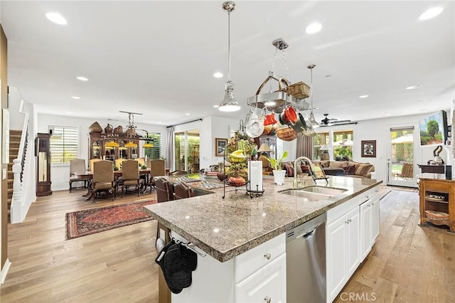 kitchen with a wealth of natural light, sink, stainless steel dishwasher, and light wood-type flooring