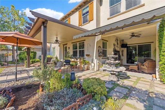 rear view of property featuring ceiling fan and a patio