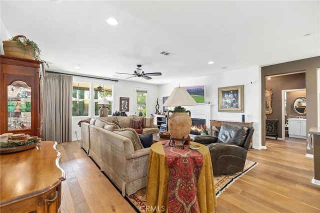 living room with ceiling fan and light hardwood / wood-style floors