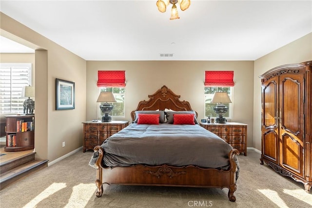 bedroom with light colored carpet and multiple windows