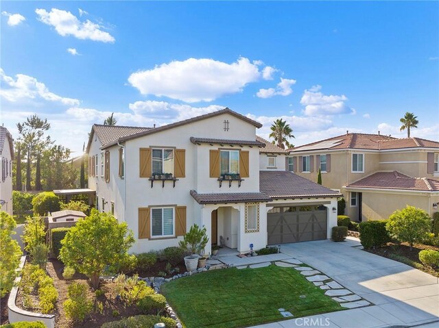 mediterranean / spanish house with a garage and a front yard