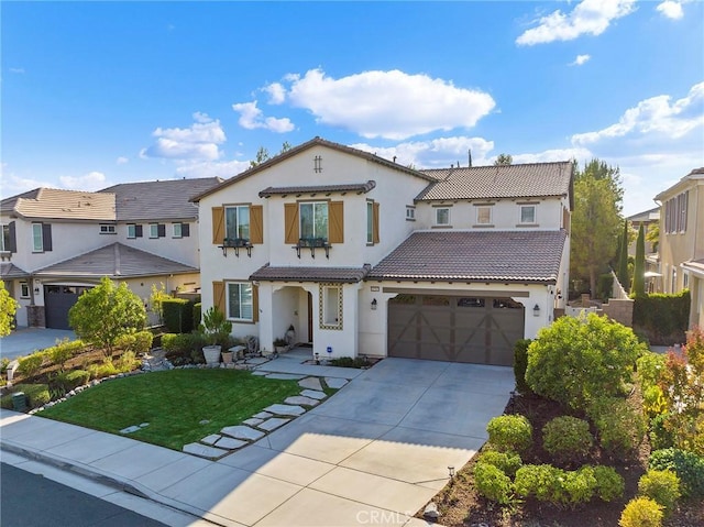 mediterranean / spanish home featuring a front yard and a garage