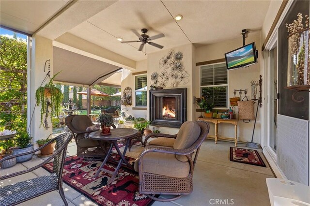 view of patio featuring ceiling fan and an outdoor fireplace