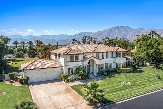 mediterranean / spanish home with a garage, a mountain view, and a front yard