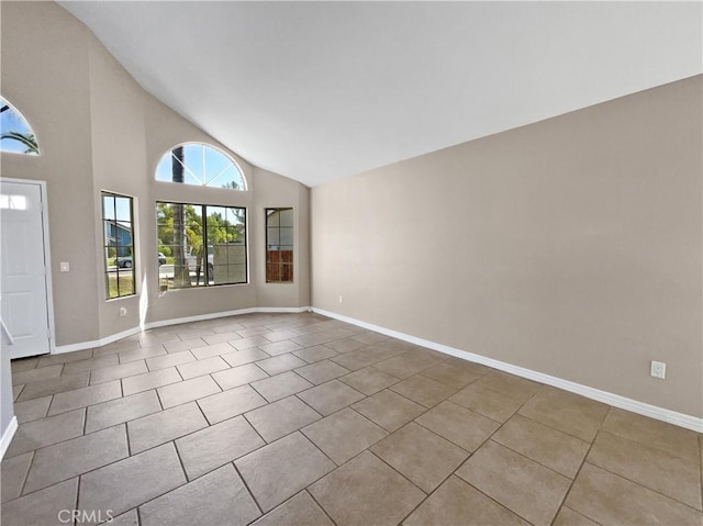 tiled spare room featuring high vaulted ceiling