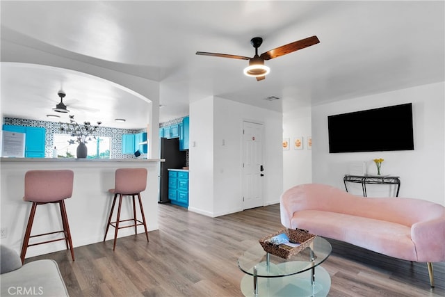 living room featuring wood-type flooring and ceiling fan