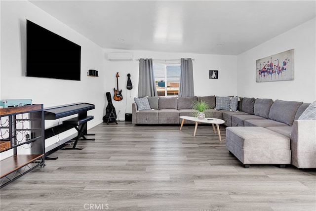 living room featuring a wall mounted air conditioner and light hardwood / wood-style flooring