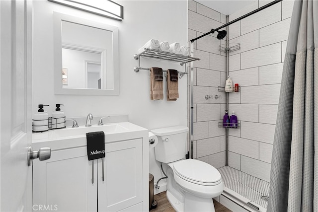 bathroom featuring toilet, curtained shower, vanity, and hardwood / wood-style flooring