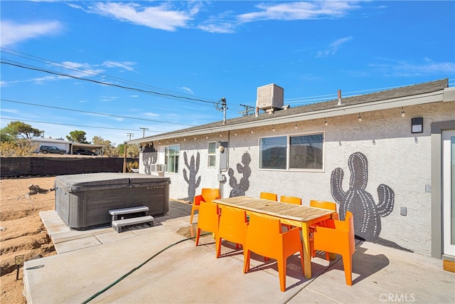 rear view of property with a hot tub, a patio, and central AC unit