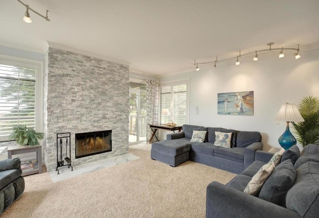 living room featuring plenty of natural light, crown molding, and a stone fireplace