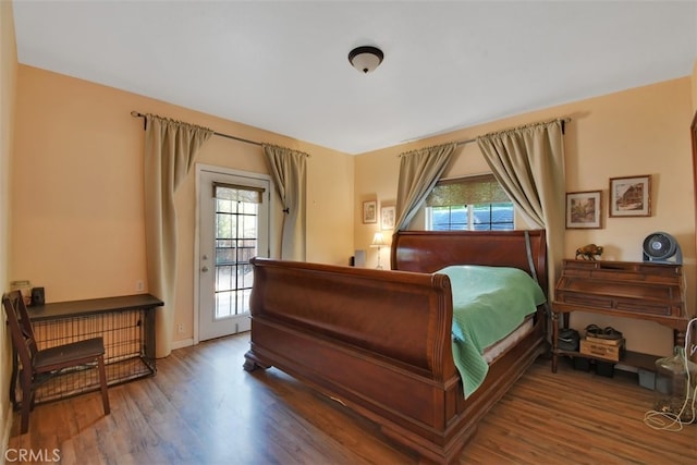 bedroom with access to outside and wood-type flooring