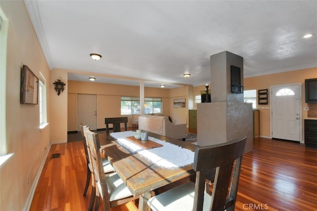 dining space with ornamental molding and hardwood / wood-style floors