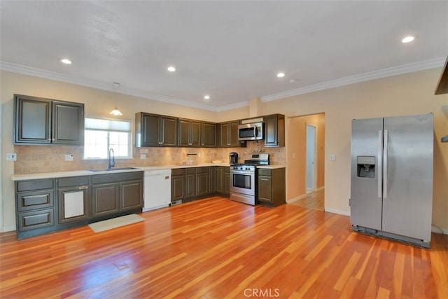 kitchen featuring decorative backsplash, stainless steel appliances, sink, crown molding, and light hardwood / wood-style floors