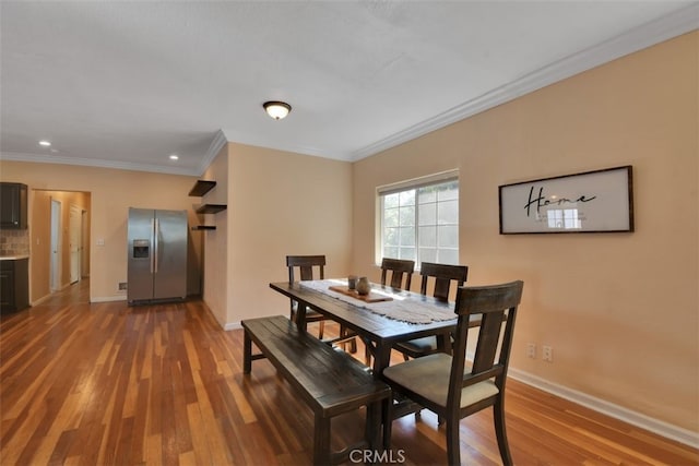 dining space featuring hardwood / wood-style flooring and ornamental molding