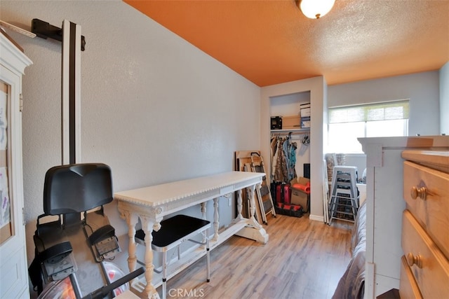 office area with light hardwood / wood-style flooring and a textured ceiling