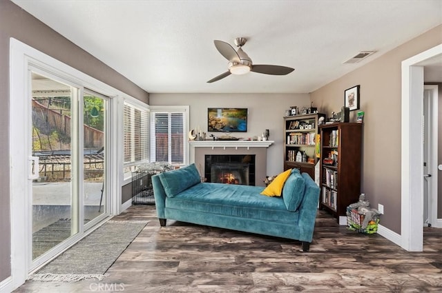 living room with dark hardwood / wood-style floors, a fireplace, and ceiling fan