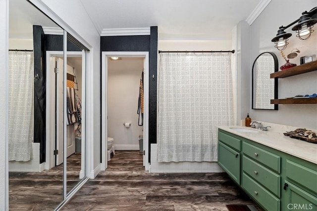 full bath featuring toilet, wood finished floors, vanity, and crown molding