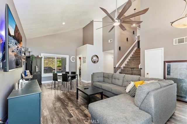 living room featuring a textured ceiling, dark hardwood / wood-style floors, high vaulted ceiling, and ceiling fan