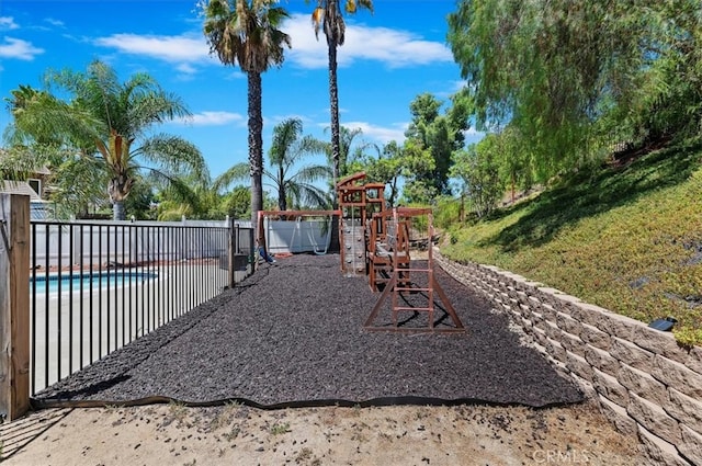 view of playground featuring fence and a fenced in pool