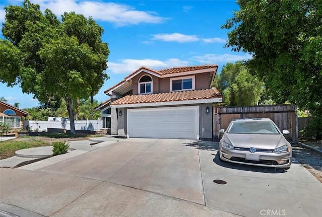 view of front of home featuring a tile roof, fence, an attached garage, and stucco siding