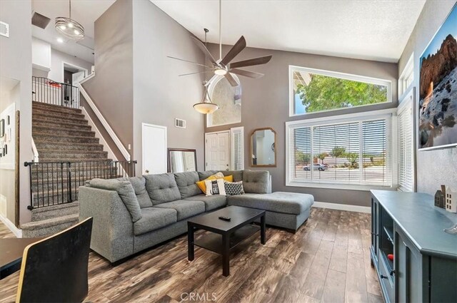 living room featuring dark hardwood / wood-style floors, high vaulted ceiling, and ceiling fan