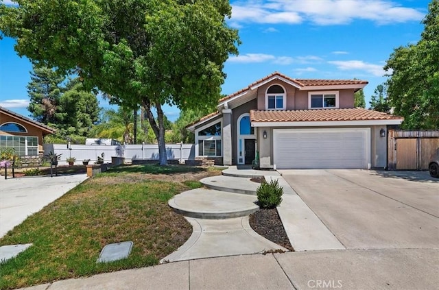 mediterranean / spanish home featuring a tile roof, stucco siding, an attached garage, fence, and driveway