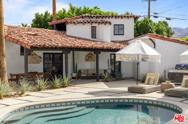 back of property featuring a patio and an outdoor hangout area